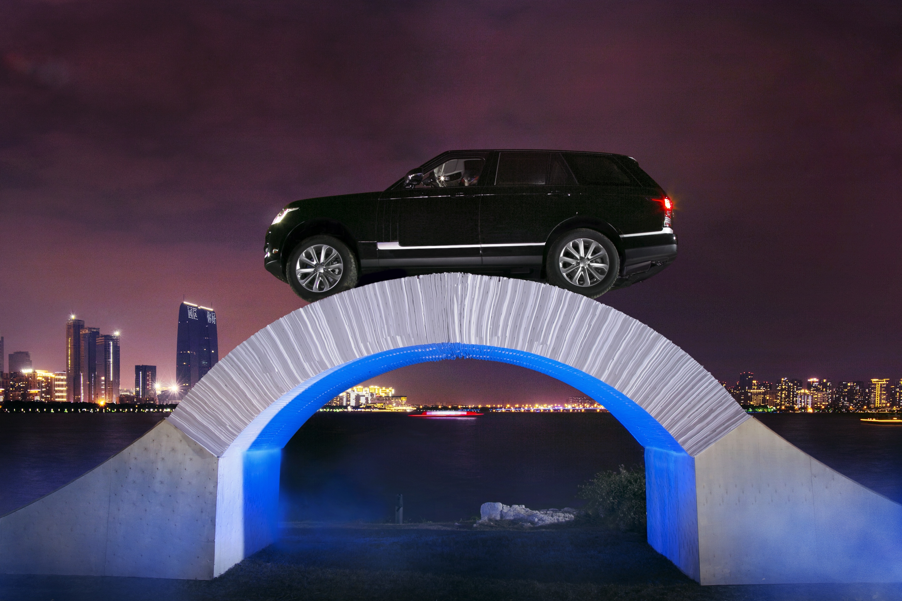 Papierkunst-Brücke trägt fahrenden Range Rover 